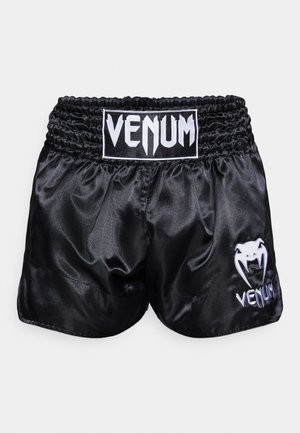 Calções de boxe de cetim pretos com um cós elástico; apresentam um logo branco e um desenho de cobra na perna esquerda. Textura suave.