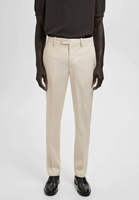 Beige maßgeschneiderte Hosen mit glatter Textur und schlanker Passform. Verfügt über einen Bund mit Gürtelschlaufen und einen einfachen Knopfverschluss.