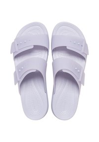 Lila rubberen sandalen met twee verstelbare banden en kleine witte knoopaccenten. Getextureerde voetbed voor comfort en slipvaste bodem.