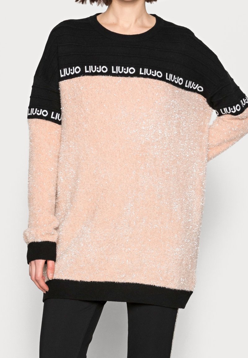 Hellrosa, flauschiger Pullover mit schwarzen, gerippten Akzenten und Logoband. Verfügt über eine lockere Passform und lange Ärmel. Weiche Textur mit gemütlichem Aussehen.