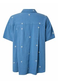 Chemise bleue à manches courtes avec petits motifs de marguerites blanches, tissu texturé et un détail de pli doux dans le dos sous le yoke.