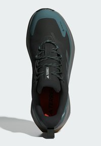Schwarz und türkisfarbene Wanderschuhe mit einer strukturierten Oberseite, Schnürsystem und Gummisohle. Verfügt über ein GORE-TEX-Schild und einen Zugriemen an der Ferse.