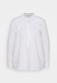 Camicia bianca a maniche lunghe con colletto arricciato e smocking testurizzato sulle spalle. Presenta una chiusura a bottoni e una vestibilità morbida.
