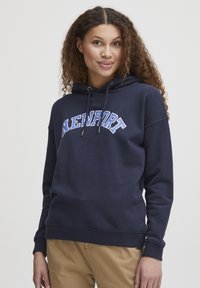 Felpa blu navy in misto cotone, con tasca a marsupio, polsini a costine, cappuccio regolabile con cordoncino e stampa "NEWPORT" in bianco e blu.