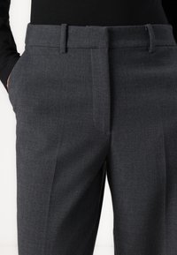Sive krojene hlače od glatke tkanine, s ravnim prednjim dijelom, bočnim džepovima i elegantnim dizajnom s petljama za remen.