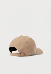 Καφέ καπέλο μπέιζμπολ με καμπύλη τρύπα, βαμβακερό υλικό, ρυθμιζόμενο λουρί στο πίσω μέρος και ραμμένο κουμπί στην κορυφή. Καθαρός, μινιμαλιστικός σχεδιασμός.