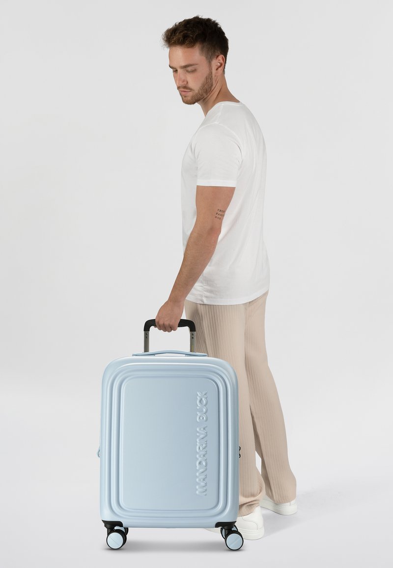 Valigia rigida blu chiaro con design rigato, maniglia per il trasporto e quattro ruote girevoli. Logo "Mandarina Duck" in evidenza.