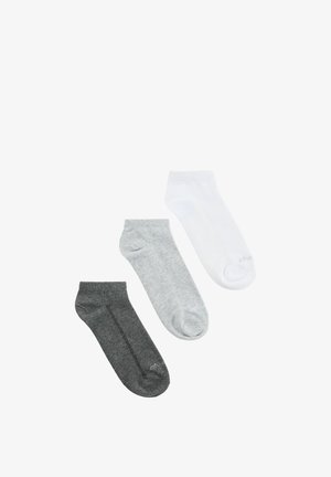 Trzy skarpety do kostki w kolorach ciemnoszarym, jasnoszarym i białym, ułożone diagonalnie na białym tle.