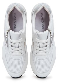 Paire de baskets en cuir blanc perforé avec lacets et fermetures éclair latérales, nom de marque Cesare Gaspari visible à l'intérieur.