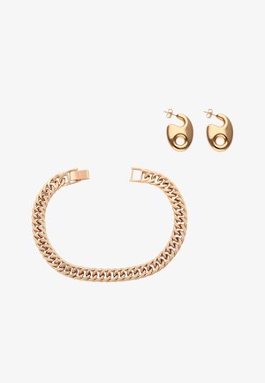 Brățară cu lanț din aur roz cu verigi groase și cercei asortați, în formă abstractă, cu decupaje circulare, pe fundal alb.