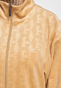 Karl Kani CHEST SIGNATURE MONOGRAM VELVET - Sportinė striukė - sand