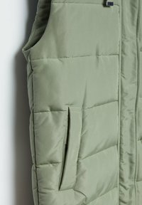 Gepolsterte ärmellose Weste in Hellgrün, mit einer mit Reißverschluss versehenen Tasche, gestepptem Design und glattem Außenmaterial.