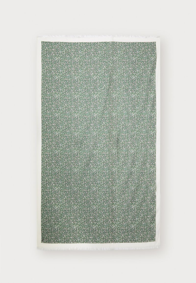 Couverture verte à motifs avec un design de feuilles, bordée de franges blanches, fabriquée en matériau textile doux.