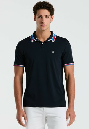 Marineblauw polo shirt met een twoknoopsluiting, witte en rode gestreepte kraag en mouwaccenten, met een klein geborduurd logo op de borst.