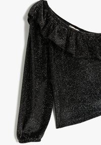 Zwarte fluwelen off-the-shoulder top met een gerimpelde halslijn, lange mouwen en verspreide zilveren versieringen. Zachte textuur en aansluitend ontwerp.