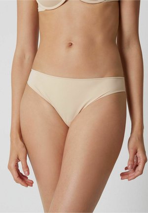 Bas de bikini beige avec une texture lisse, coupe taille basse et design minimaliste. Présente une bande de taille fine et des bords sans couture.