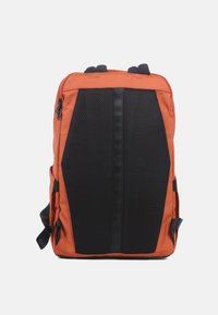 Sac à dos orange avec un dos en maille noire, arborant un design élégant, des bretelles ajustables et une fermeture éclair centrale. Comprend des poches latérales.