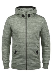 Sudadera con cremallera de color verde claro jaspeado, con bolsillos frontales, capucha ajustable, puños y bajo de canalé.