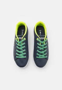 Marineblauwe sneakers met een glad leren bovenwerk, neon groene veters en accenten, witte rubberen zool, voorzien van een logo aan de zijkant en een gevoerde kraag.