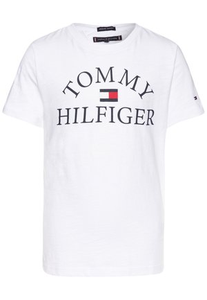Hvid T-shirt med korte ærmer med sort "TOMMY HILFIGER" tekst og et lille rødt, hvidt og blåt rektangulært logo i midten.
