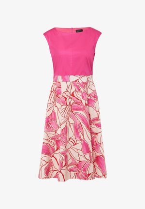 Robe rose avec un corsage ajusté et une jupe évasée. La jupe présente un motif floral rose et rouge sur un fond crème.