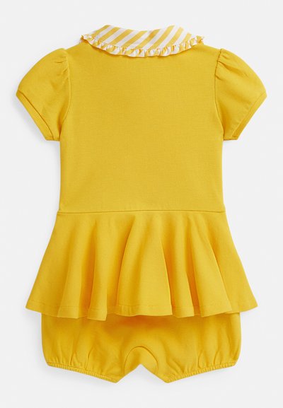 Kollane lühikeste varrukatega kombinesoon peplum-vöökohaga, tekstuurse kangaga ja triibulise kraega, millel on volangidega ääris. Elastsed säärte avad.