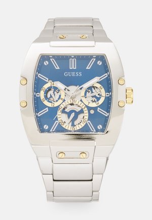 Silver stainless steel watch with a blue dial, gold accents, three sub-dials, and a rectangular case design featuring luminous hands and markers.