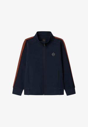 Giacca zip-up blu navy con strisce rosse lungo le maniche e piccolo logo a forma di diamante sul lato sinistro del petto.