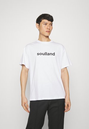 Hvit bomull t-skjorte med kortermede og rund hals, med teksten "soulland" i fet svart skrift over brystet.