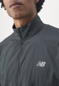 New Balance ATHLETICS REFLECTIVE PACKABLE JACKET - Veste de running - blacktop