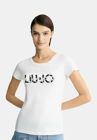 T-shirt bianca a maniche corte con il nome del marchio "LIU•JO" in decorazioni black and white, colletto rotondo e design aderente.