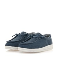 Scarpe di tela blu con suole in gomma bianche, caratterizzate da una superficie liscia, forma arrotondata e lacci decorativi per la chiusura.
