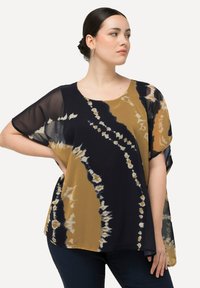 Top ampio in tessuto trasparente con motivo tie-dye, caratterizzato da tonalità di blu navy, oro e beige. Collo rotondo e maniche corte.