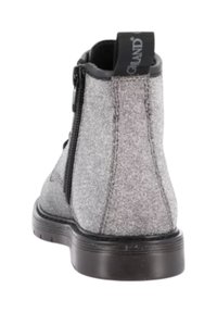 Stivaletto in tessuto grigio con suola nera, cerniera laterale, linguetta nera sul retro e dettagli di cucitura verticale visibile.