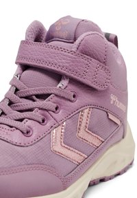 Lilla højtop sneaker med velcrobånd, snørebånd, tekstureret sål og glitrende chevron-design på siden.
