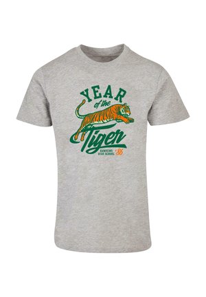 Harmaat puuvillapaita, jossa on vihreä ja oranssi kuva hyppäävästä tiikeristä, tekstinä "TIJOISTA Tiikeri HAWKINS YLIOPISTO '86."