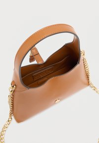 Sac à main en cuir marron avec un dessus incurvé, une bandoulière chaîne dorée, une fermeture magnétique et un intérieur non doublé avec une étiquette de marque.