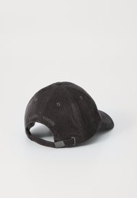 Dark gray corduroy baseball cap with a curved visor, adjustable strap, and metal buckle; features stitching accents along the back.