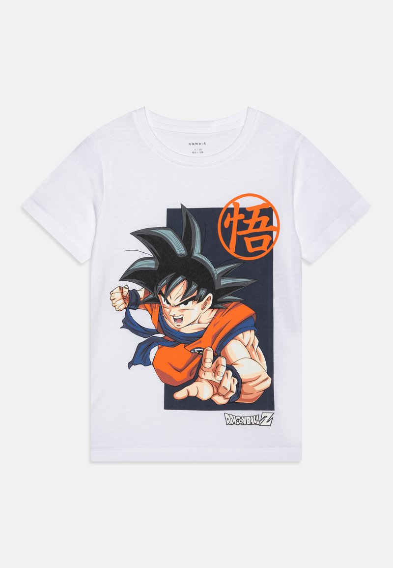 T-shirt en coton blanc avec un graphisme d'un personnage de dessin animé aux cheveux noirs en piques, portant une tenue orange et bleue, avec un emblème circulaire.