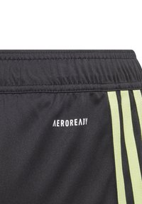 Pantalones cortos de deporte negros con una tela texturada, cinturilla elástica y franjas laterales de color amarillo brillante. Logo "AEROREADY" en blanco.