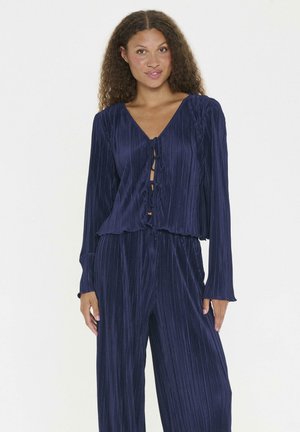 Marineblaues, plissiertes Zweiteiler-Outfit mit langen Ärmeln, V-Ausschnitt und gebundenem Frontdetail; weicher, strukturierter Stoff mit entspanntem Schnitt.