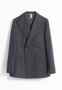 Blazer de doble botonadura de color gris oscuro, hecho de una tela texturizada. Presenta grandes solapas, tres bolsillos frontales y seis botones a juego.