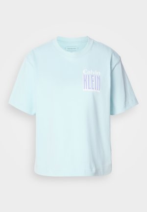 Lichtblauw katoenen T-shirt met een ronde hals en korte mouwen. Heeft een grafisch ontwerp met "Calvin Klein" in paars op de voorkant.