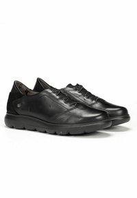 Chaussures en cuir noir avec un bout rond, détails texturés sur le dessus et lacets élastiques. Comprend une semelle rembourrée pour le confort.