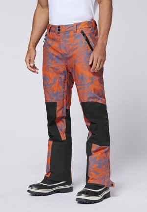 Helle orange, wasserdichte Hose mit grauen Blumenmustern und schwarzen Akzenten. Sie verfügt über zwei mit Reißverschluss versehenen Taschen und ein gerades Bein-Design.