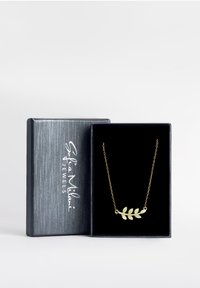 Guldfolie-design halskæde på en fin kæde, præsenteret i en mørk æske med en struktureret sølv yderside og blødt sort indre.