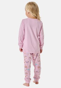 Kinderlangarmshirt in Pink mit passenden, gemusterten Schlafanzughosen, die Regenbögen, Wolken und Sterne in verschiedenen Farben zeigen. Aus weichem Baumwollstoff.