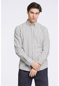 Camisa de botón con un patrón de rayas verticales en verde claro y blanco. Tela ligera, mangas largas con puños abotonados y cuello puntiagudo.