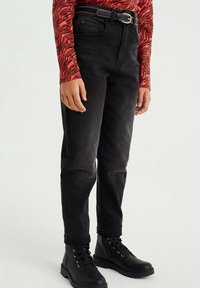 Svarta jeans i denim med raka ben, hög midja, sömmar som detaljer och ett skärp. Matchas med svarta snörstövlar.