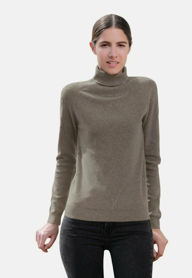 Pull à col roulé gris avec un motif en relief en forme de diamant, fabriqué à partir d'un matériau doux. Associé à un jean foncé, mettant en valeur une coupe slim et un design épuré.